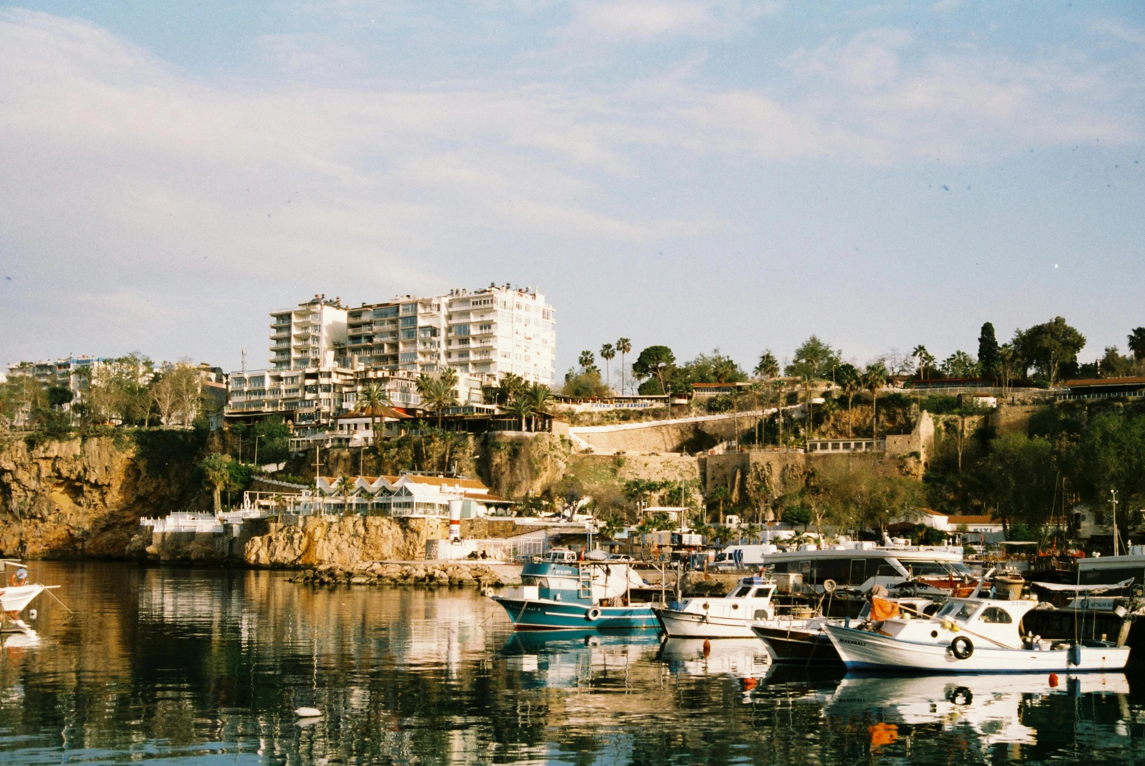 several boats sitting in the water next to a shore