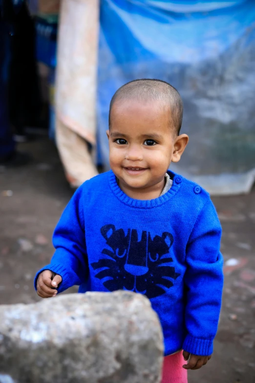 a  smiling for the camera in a blue sweater