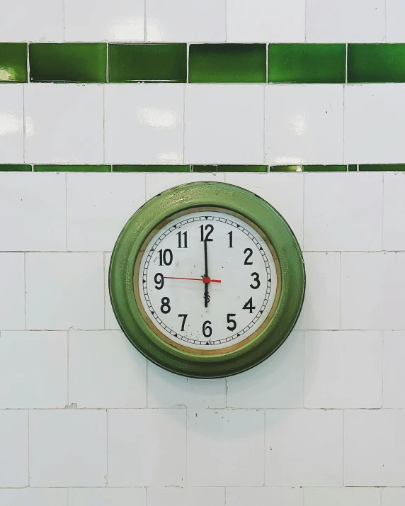 the clock on the wall is green and white