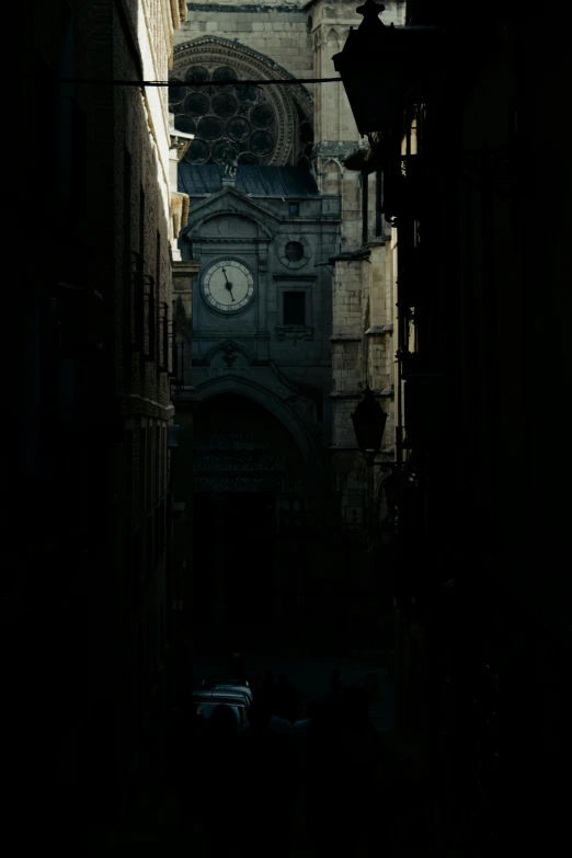 an alley way with buildings and a building with clock