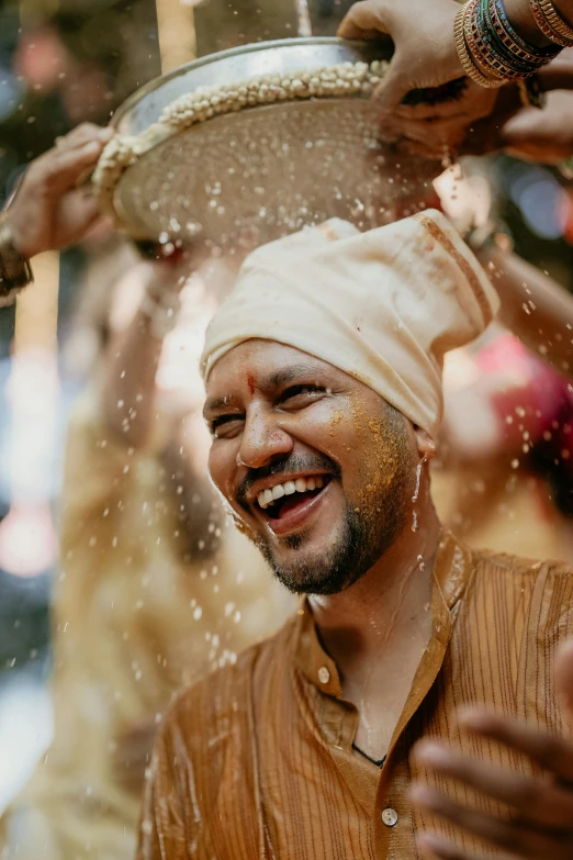 a man is smiling as he holds a pan and a pot