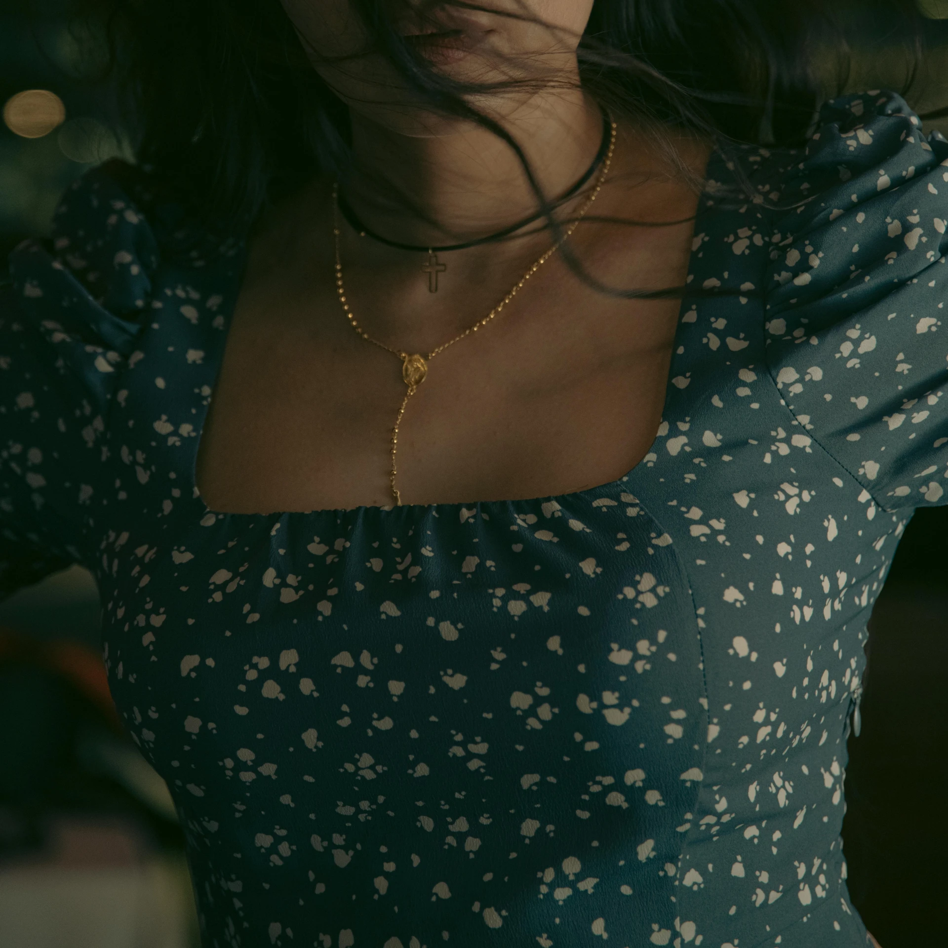 a women's blue dress with tiny flowers and gold pendant