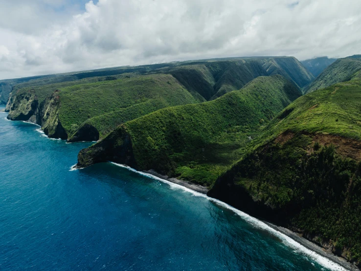 a group of hills with a blue body of water near by