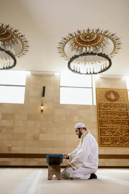 a man sits on a stool in an islamic room