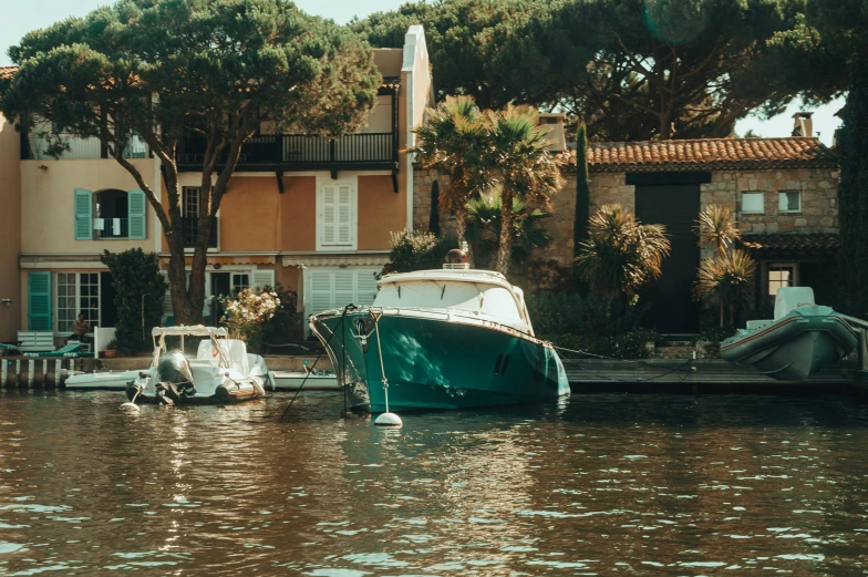 a yacht sits anchored in the water beside several docked boats