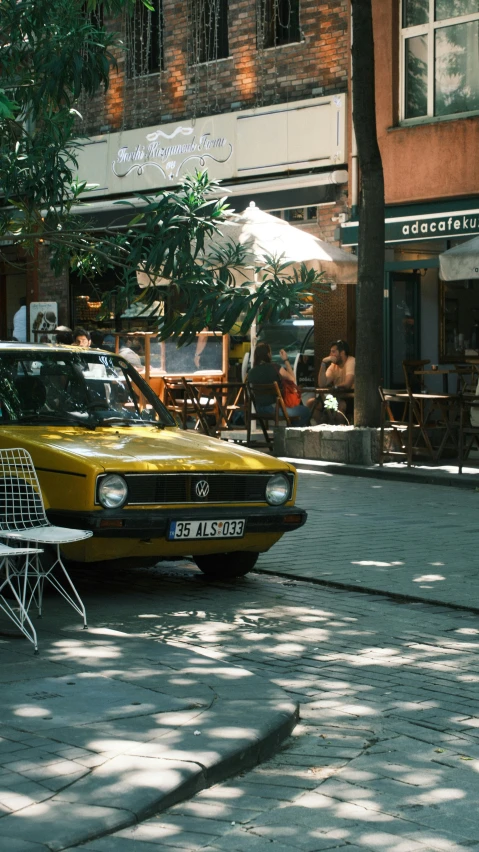 the old model car is parked outside a cafe