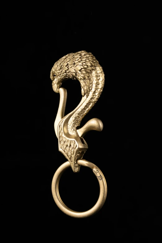 a gold colored metal ring with a snake like handle