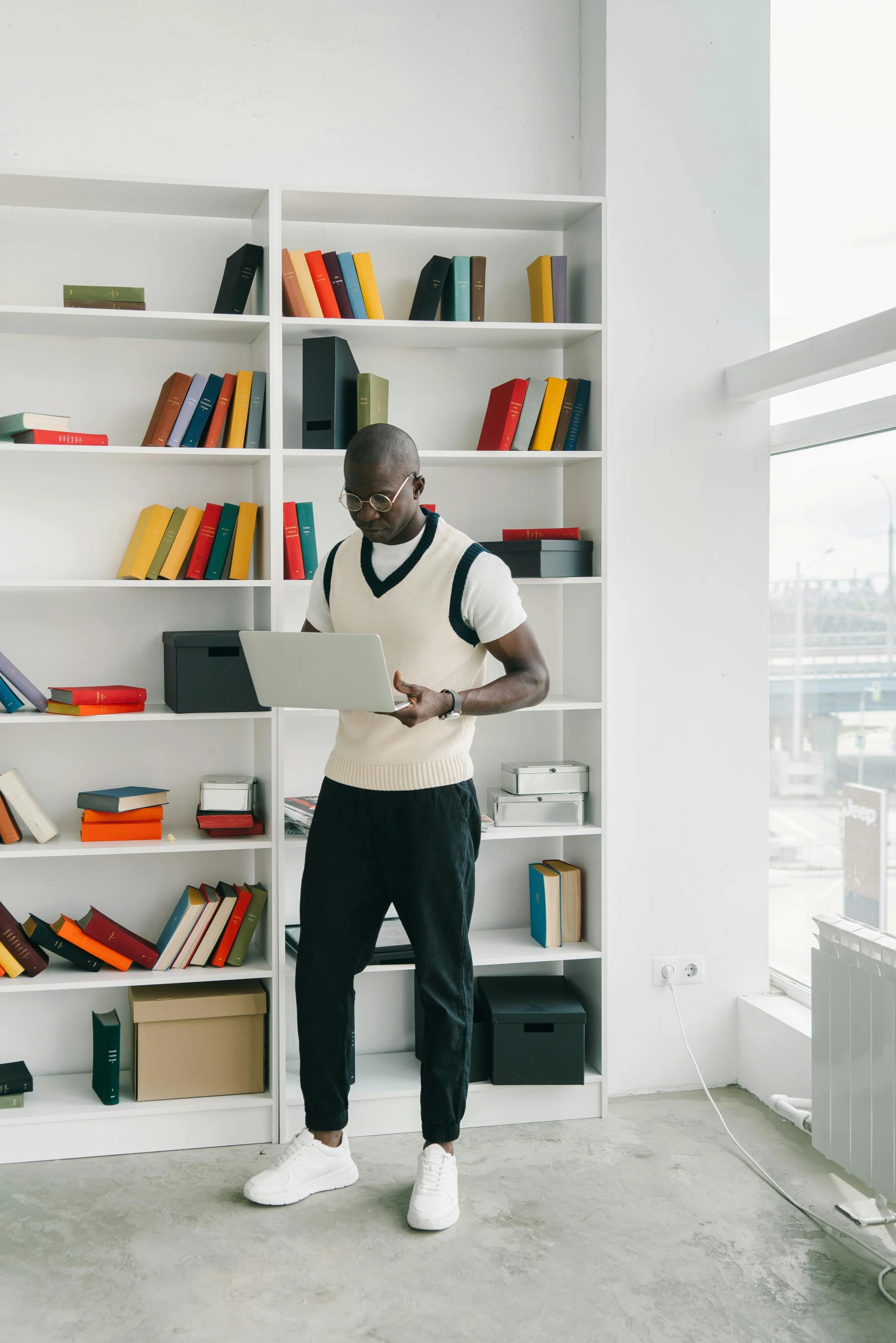 a man standing next to a book case in a room