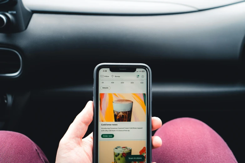 someone holding their phone while driving in a car