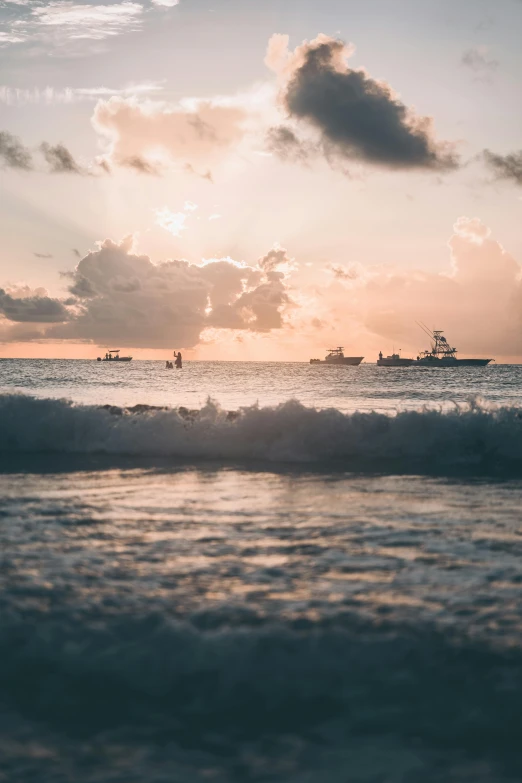 the sun rising over the ocean with small waves