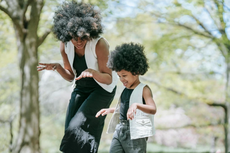 an adult and young child playing with a frisbee in the park