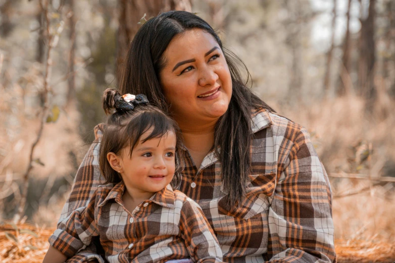 the mother holds her daughter and smiles