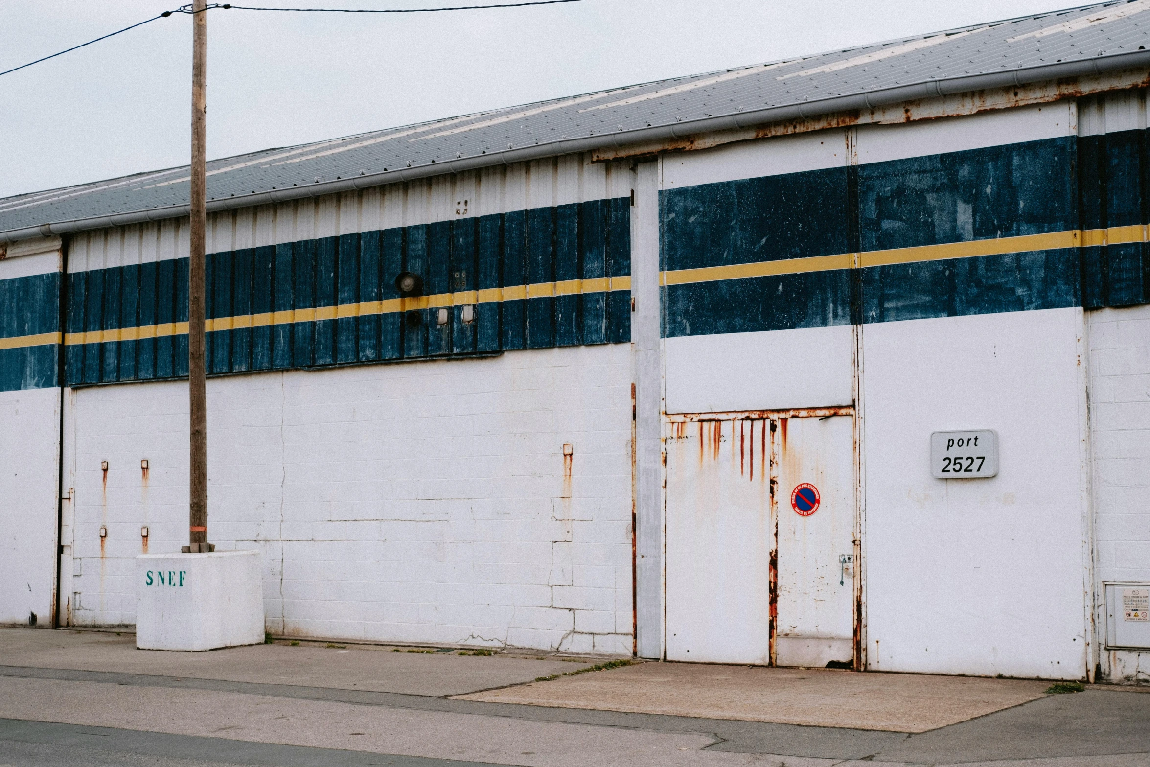 a white building on a side walk with a red stop sign