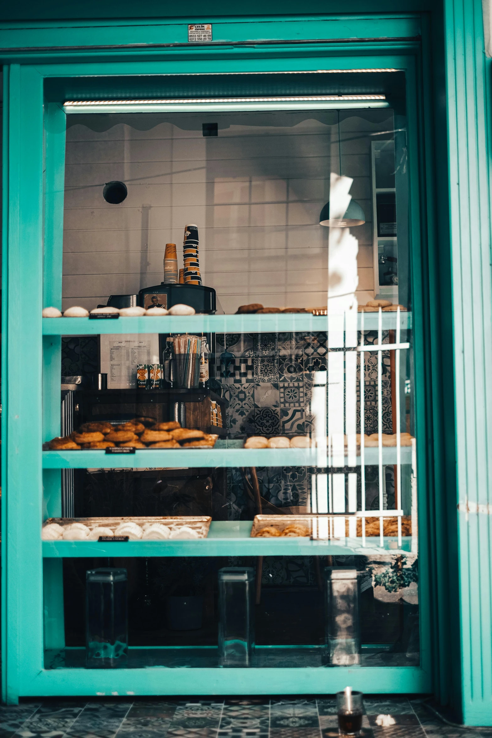 a blue shop front is holding a display of pastries and pies