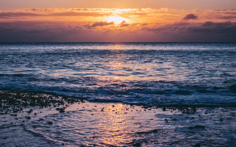 sunset or sun rays shine through the clouds over ocean