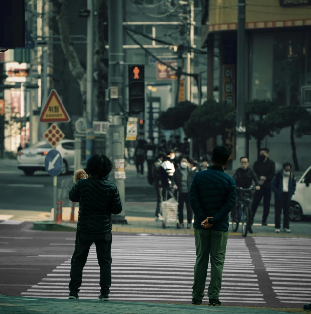 two young men looking at each other while standing next to an intersection