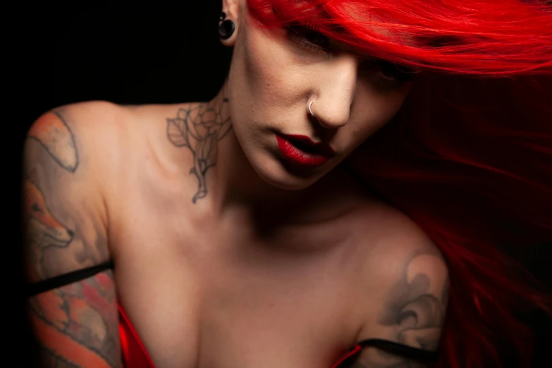 a woman with red hair and tattoos wearing a dress