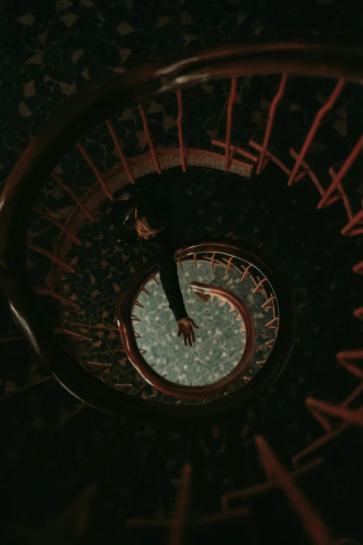 a person climbing a spiral staircase looking down