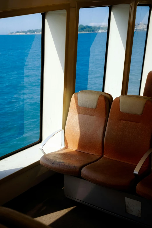 the seats in the train are facing out on the blue sea