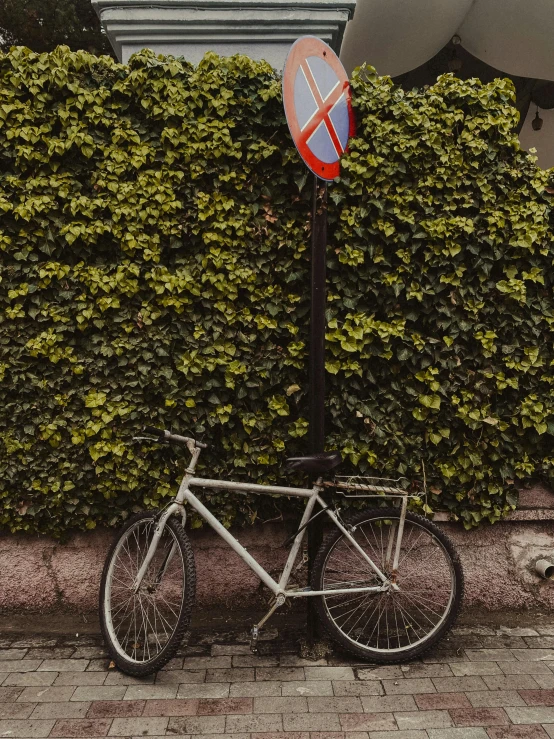 a bicycle  to a pole on the side of a building