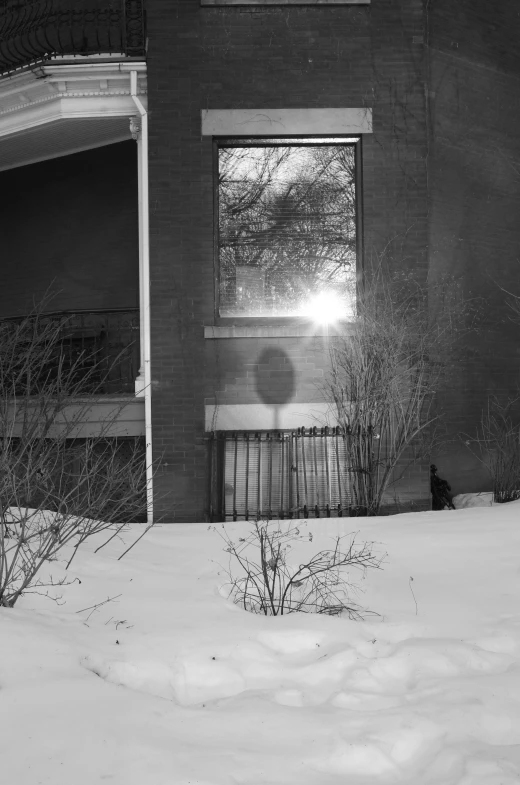 a window sitting on the side of a house covered in snow