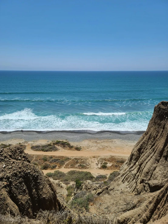 the waves roll along the beach near sand cliffs