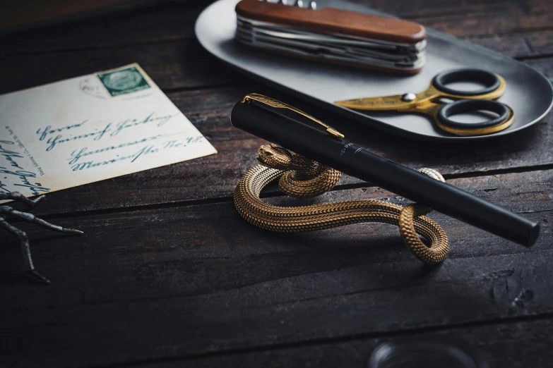 a note with a gold rope next to some scissors