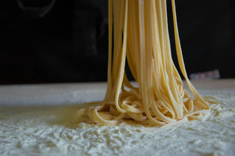 the noodles are being made by someone on the table