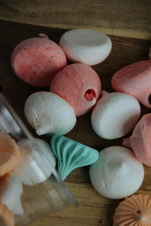 some colorful donuts with candy inside sitting on top of a wooden surface