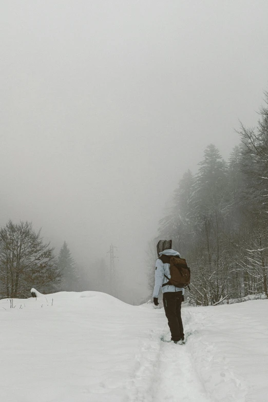 someone walking through the snow with backpack