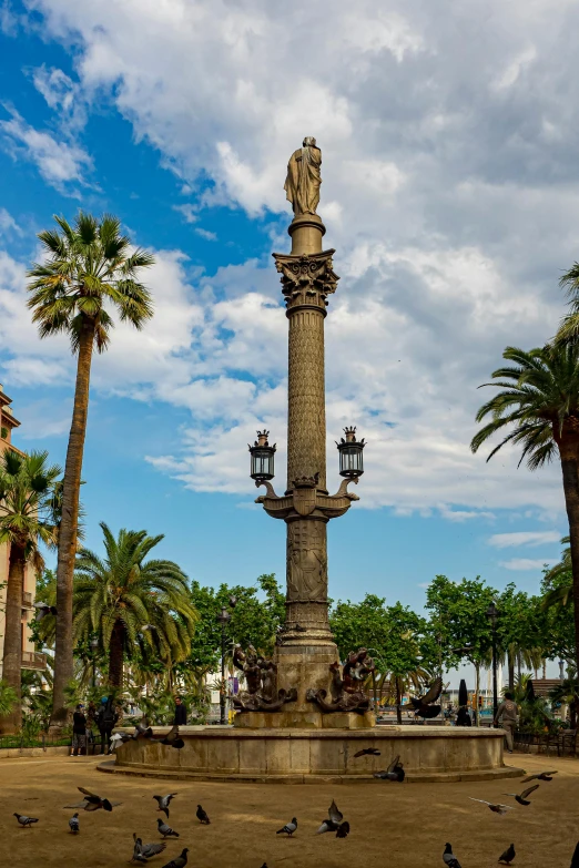 many birds gathered near the statue on a sunny day