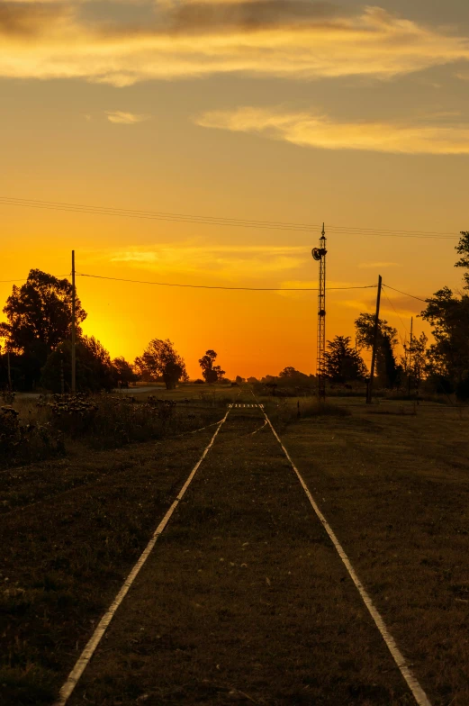 the sun is setting on the train tracks