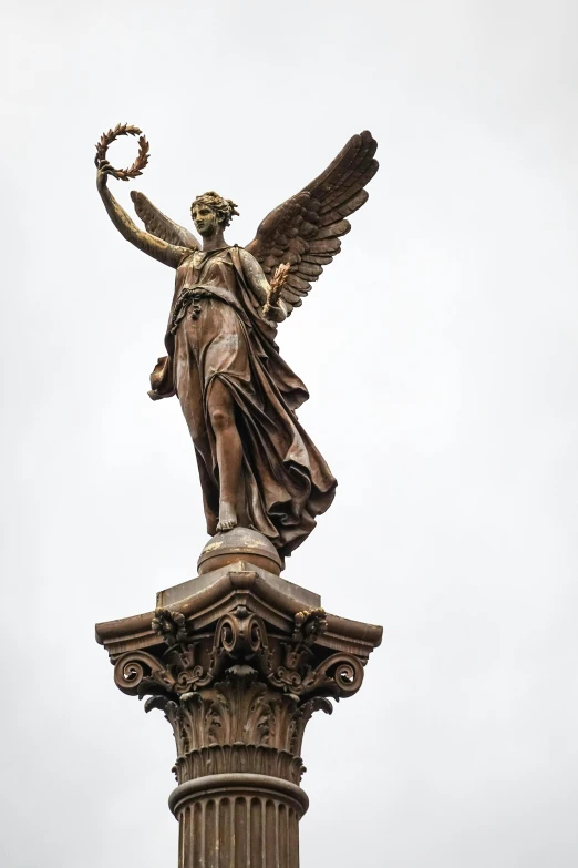 the angel statue is perched on top of the base of the column