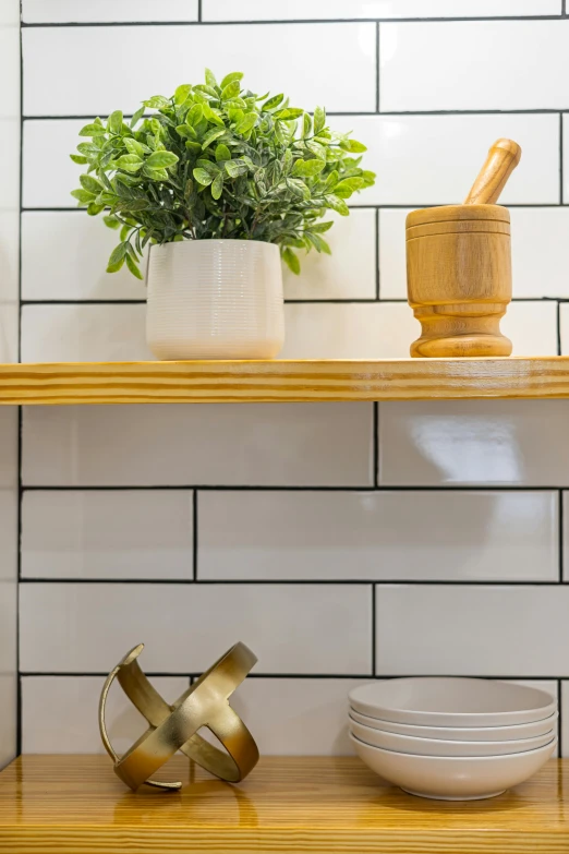 a wooden shelf sitting above some plates and a potted plant