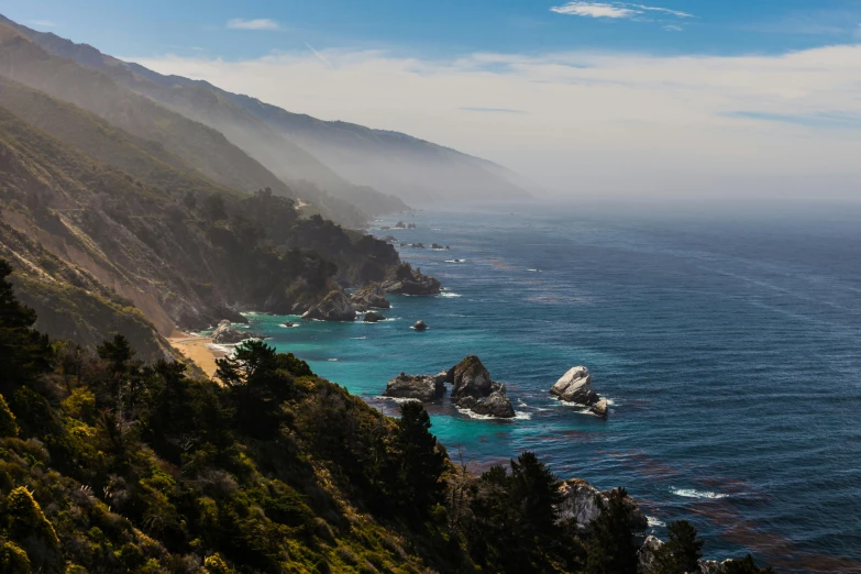 a scenic mountain coast with a big body of water in the background