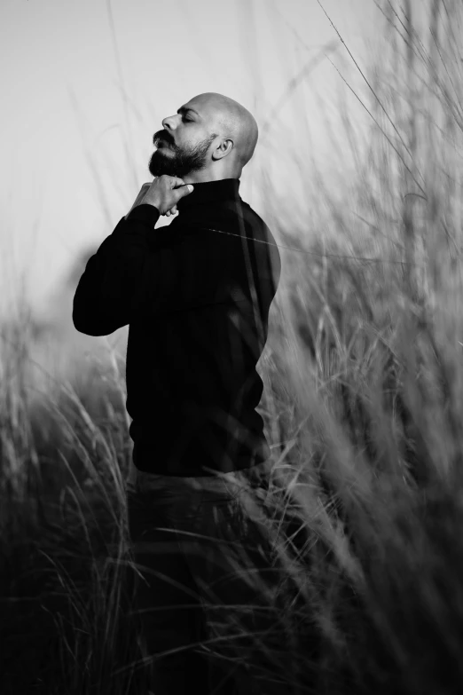 a man standing in tall grass looking into the sky