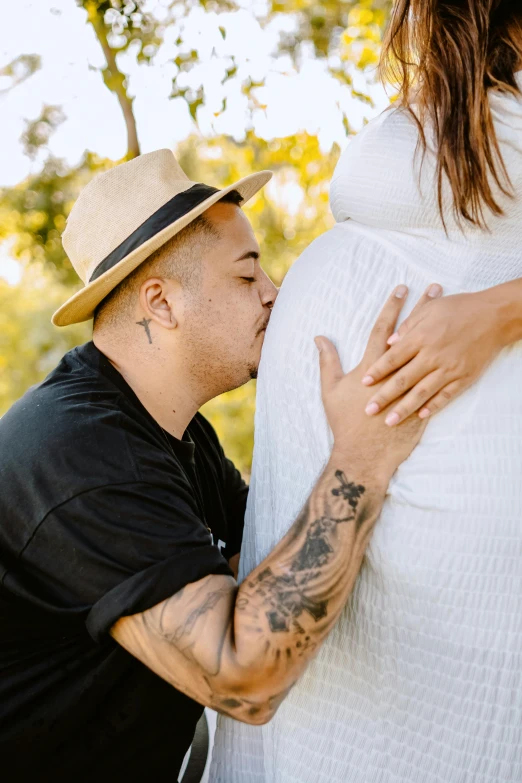 a man with tattoos and a woman kissing him