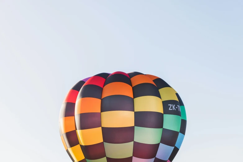 a large multicolored  air balloon flying in the sky