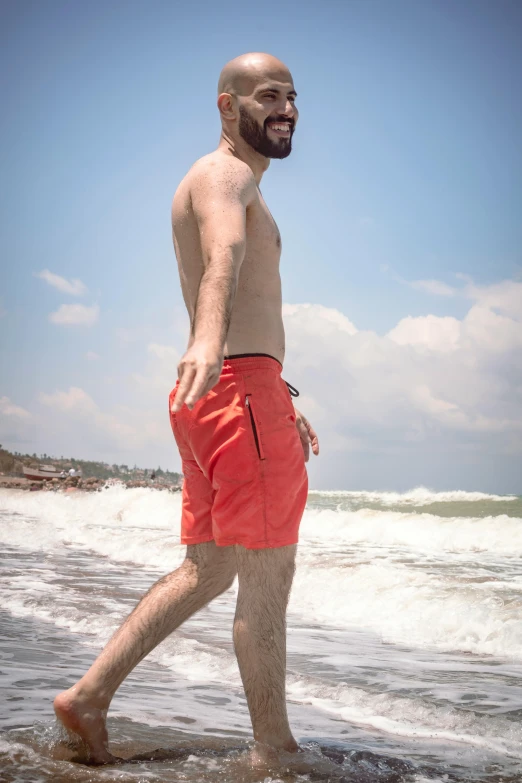 the man walks along the beach while wearing his flippers