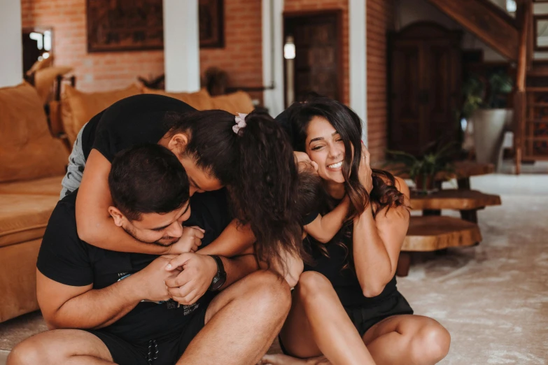 a couple hug as they lean on the floor