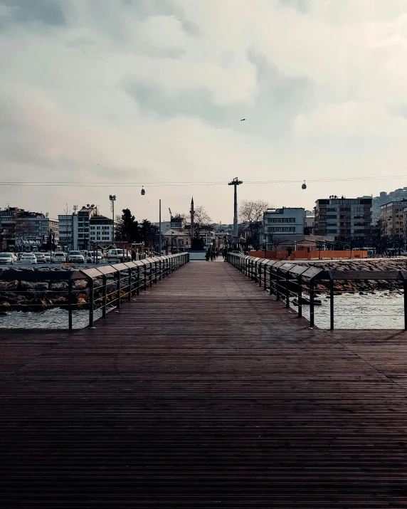 a small wooden pier near the ocean in front of some buildings