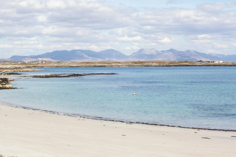 there is a beach with blue water in the sand