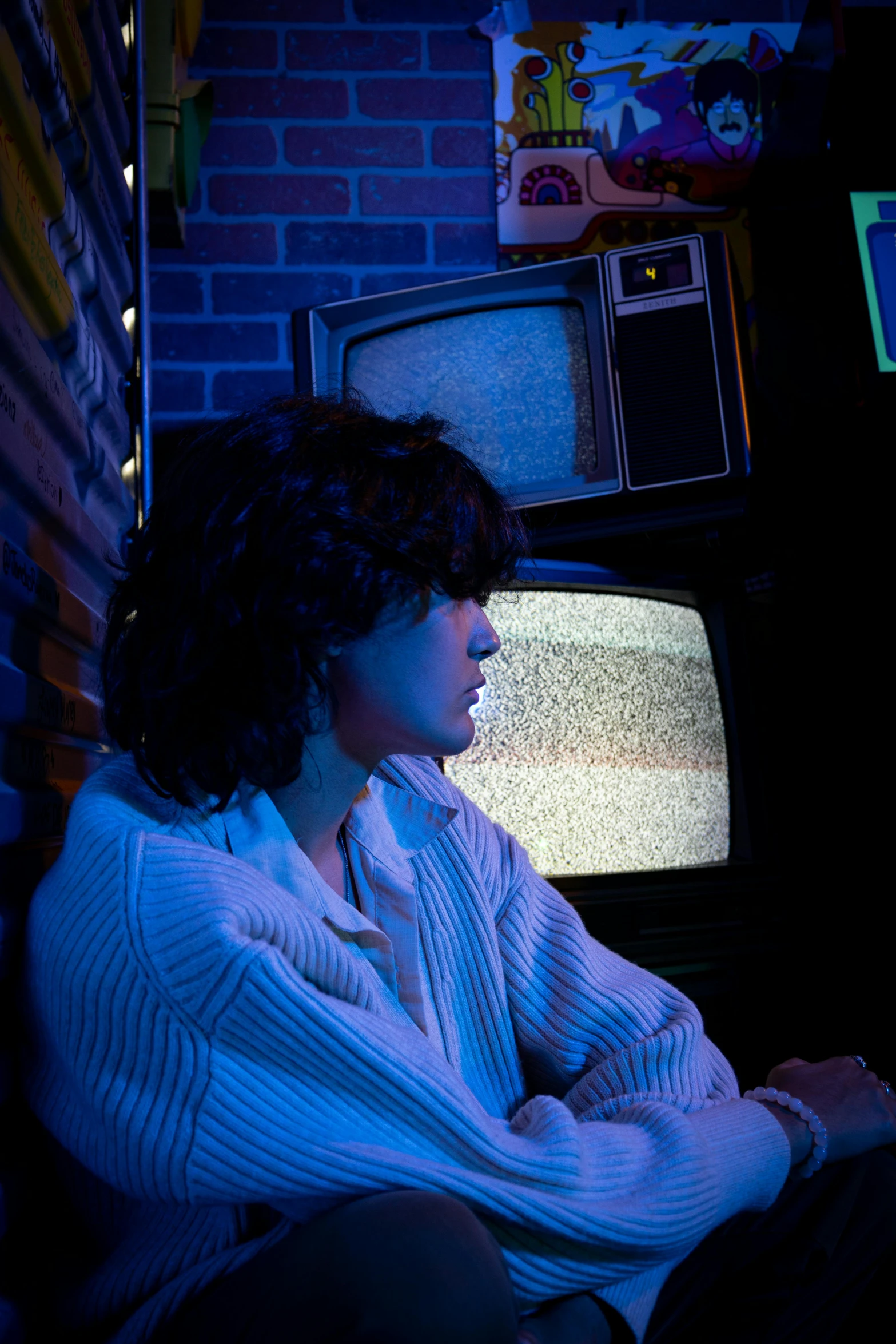 a young woman sits on a couch, watching tv