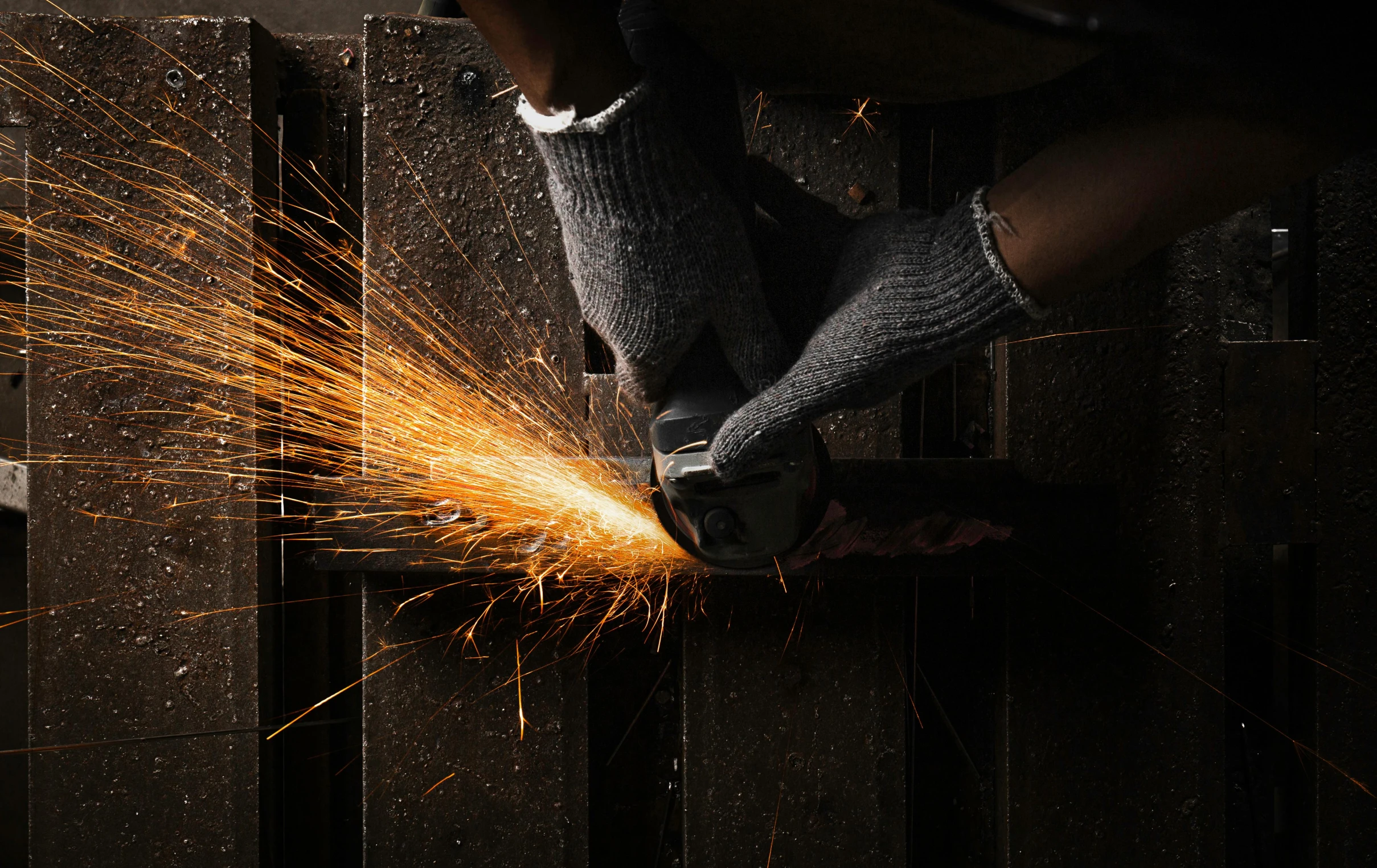 a worker grinds metal on a steel grate