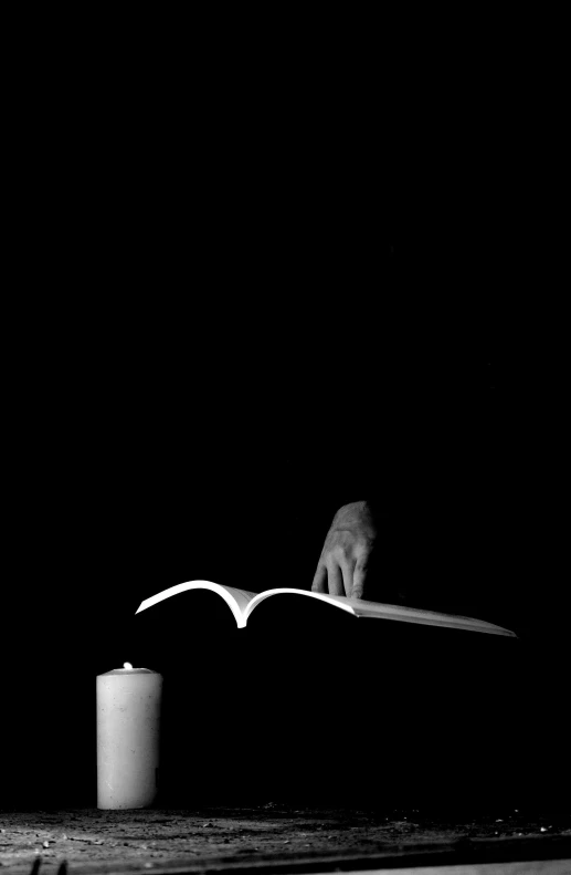 a person reading a book, in the dark