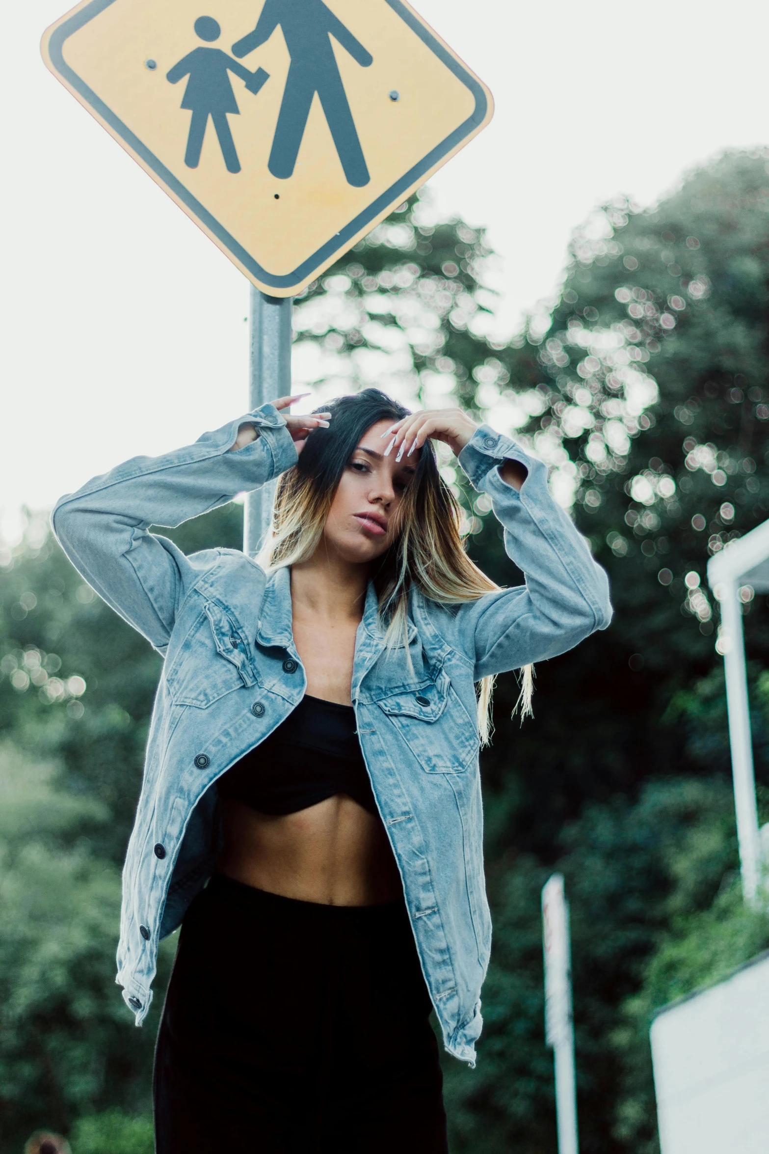 a woman covering her ears as she stands next to a traffic sign