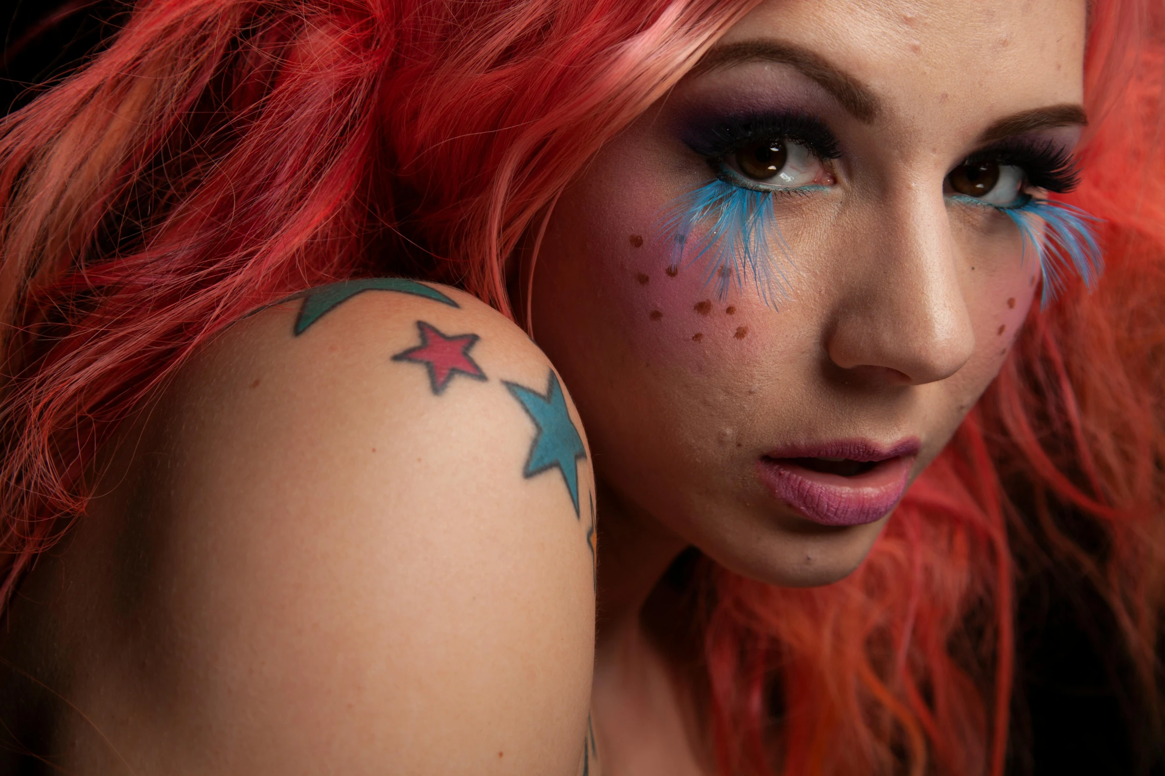 a woman with red hair and stars painted on her arm