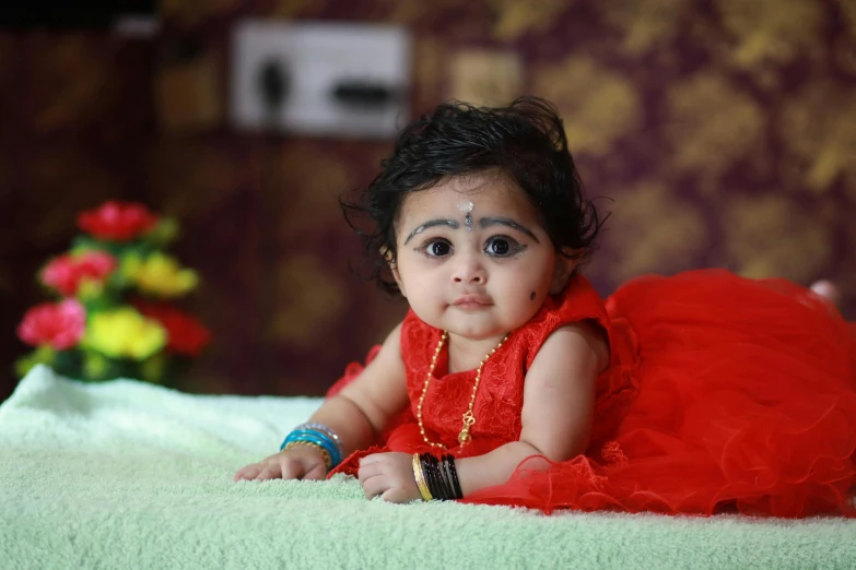 a little girl in red laying on top of a bed