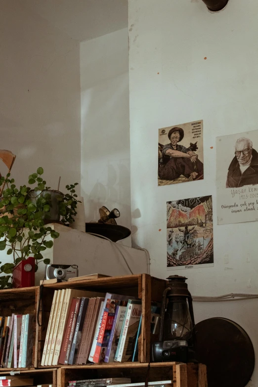 a bookshelf has many books, a vase and pictures on the wall