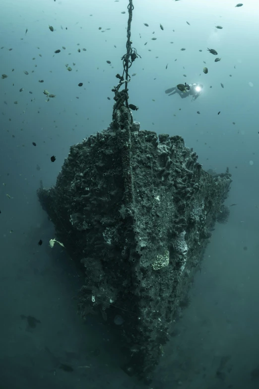 a ship sinking in the ocean and covered with rocks